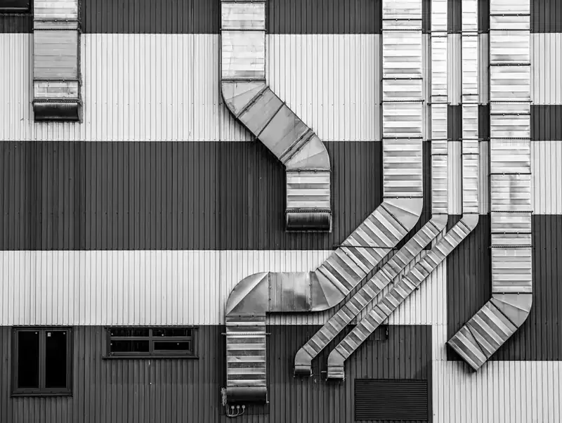 Ductos de ventilación industrial en la fachada de una nave